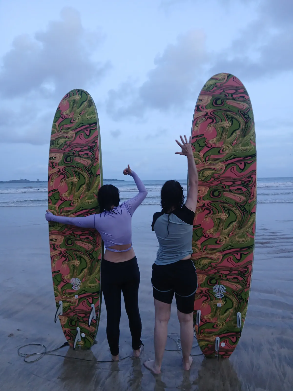 Surf boards held high on Weligama beach at sunset