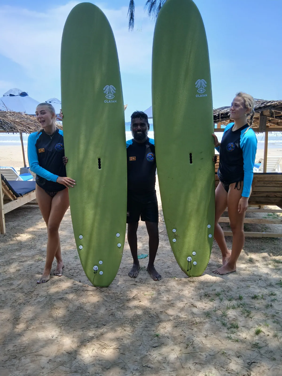 Two surfers with longboards on Weligama sand