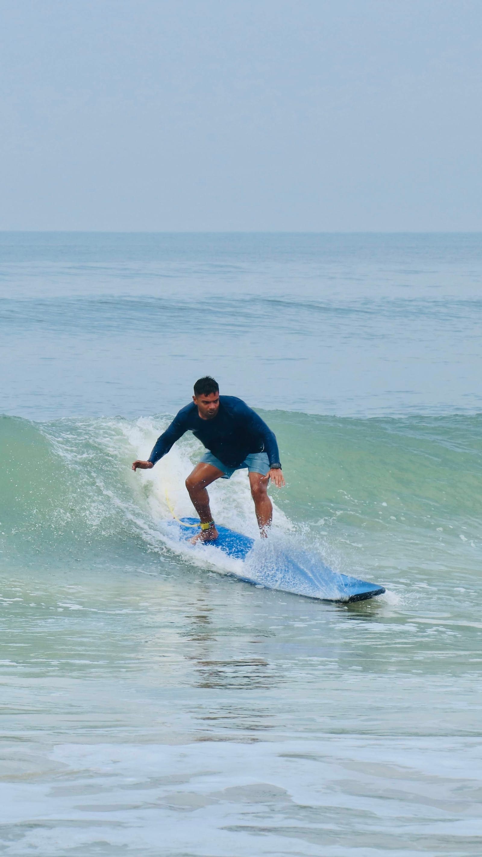 Surfer carving a wave face at Weligama surf break